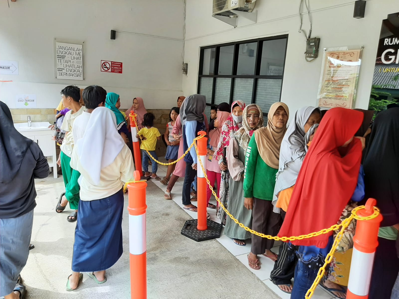 Masyarakat mengantre dengan tertib untuk menerima hidangan yang telah disiapkan oleh para relawan.