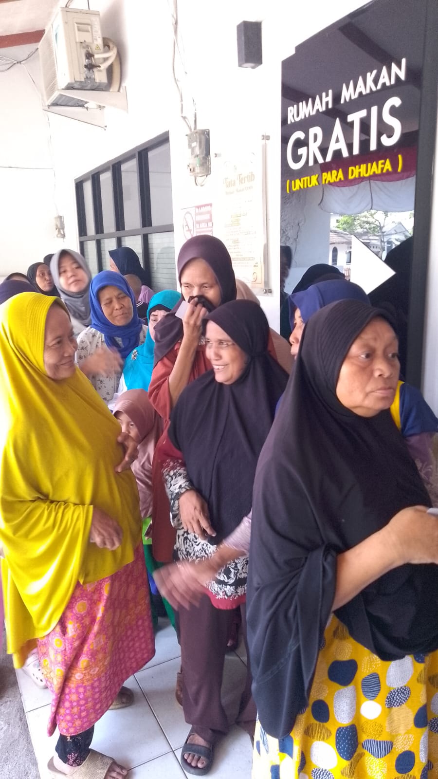 Masyarakat mengantre dengan tertib untuk menerima hidangan yang telah disiapkan oleh para relawan.
