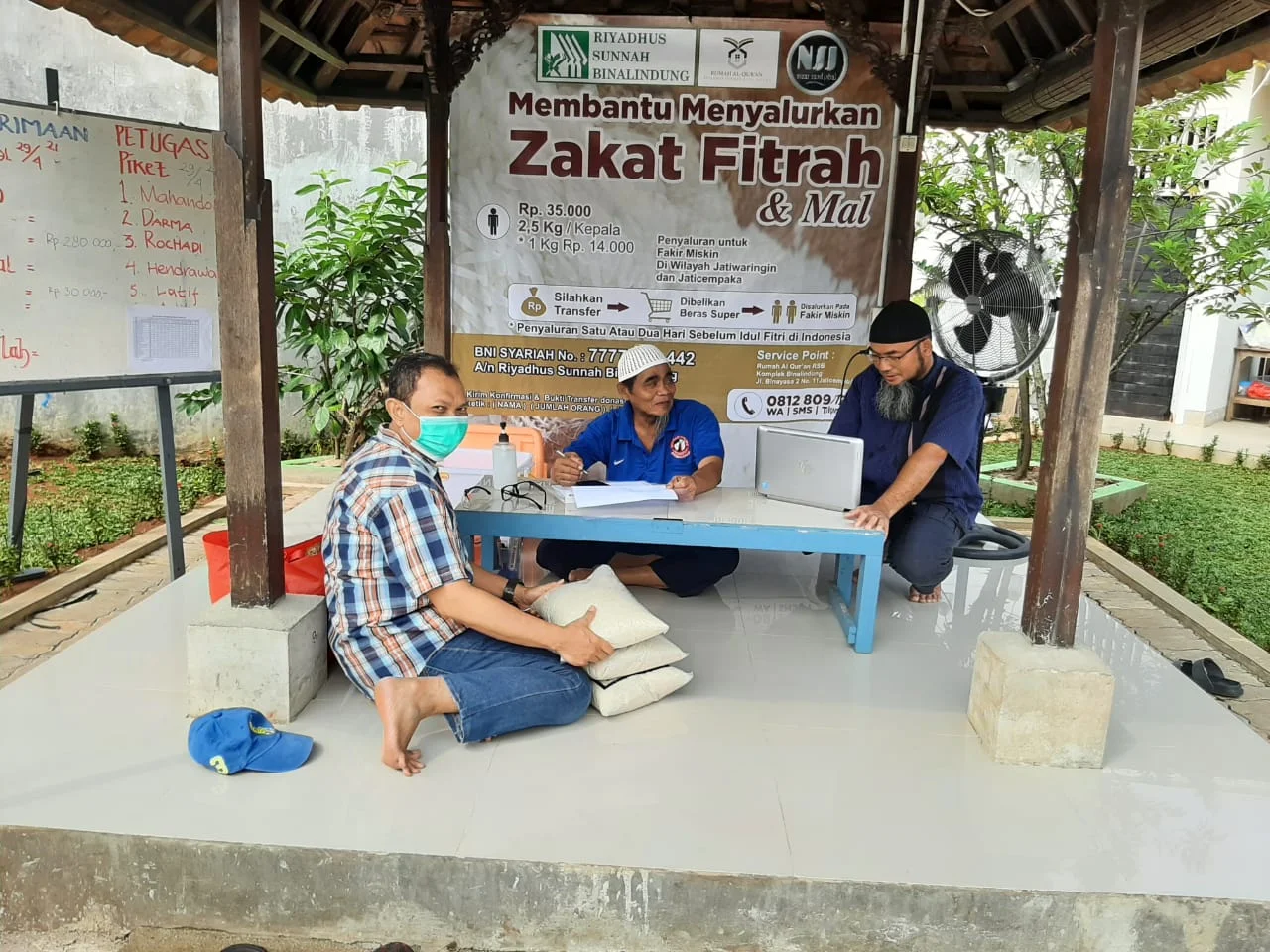 Proses penyerahan zakat fitrah oleh muzakki kepada pengurus RSB untuk didata dan disalurkan kepada penerima yang berhak.